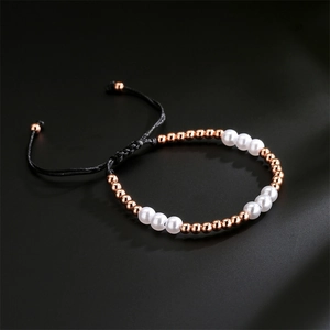 Detail of rose gold beads and white pearls on adjustable black braided cord bracelet