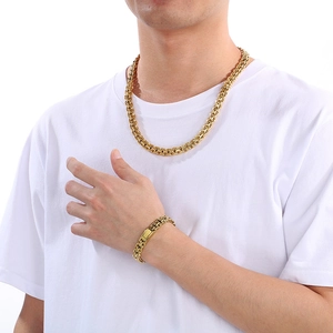 Close-up of a 10mm golden stainless steel chain necklace and bracelet set on a model