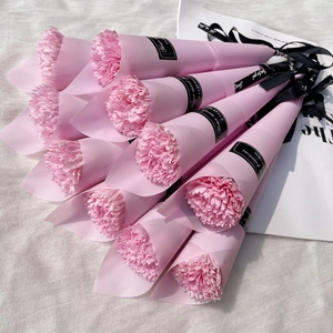 Detailed top view of pink carnation soap bouquets wrapped in paper with black ribbons