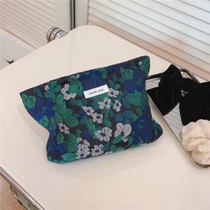 Detailed view of the blue and green floral jacquard fabric on this chic makeup pouch
