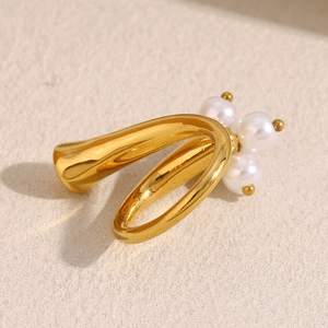 Detail of 18K gold plated ring featuring a cluster of three white pearls on curved band