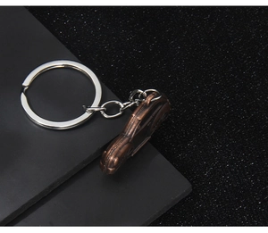 Macro view of a retro bronze car pendant keychain with a silver chain and ring