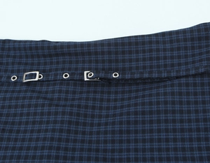 Detalle de textura de tela de cuadros azul y negro con hebilla metálica y ojales