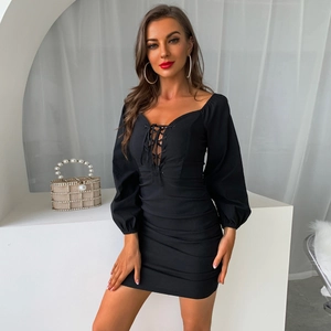 Detail of black mini dress with puffed long sleeves, tie-front, and ruched texture
