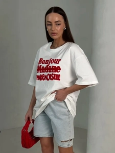 Detail of white cotton T-shirt featuring red Bonjour Madame text and stylish print