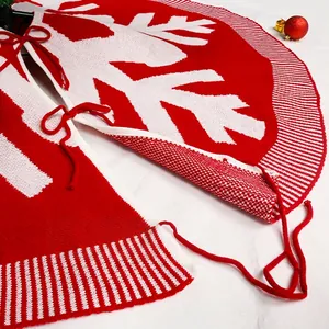 Knitted 120cm Christmas tree skirt with white snowflake patterns and red ribbon ties
