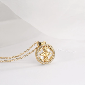 Close-up of golden evil eye pendant with white mother of pearl and sparkling zircons