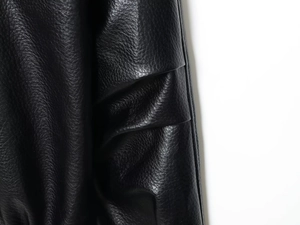 Macro detail showing the high-quality grain texture and soft luster of black leather jacket