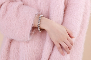 Close-up of a silver polished ball bead bracelet showing glossy finish on woman's wrist