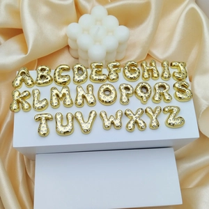 Golden balloon style 26 alphabet pendants with sparkling zircons on silk background