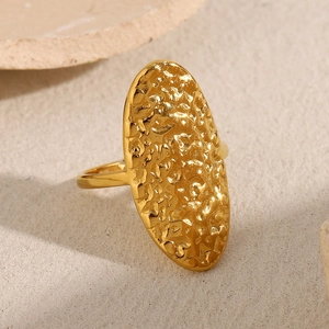 Macro detail of 18K gold plated oval ring featuring unique hammered metal texture