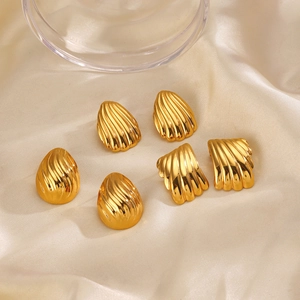 Golden geometric shell and drop earrings with striped texture on beige silk background