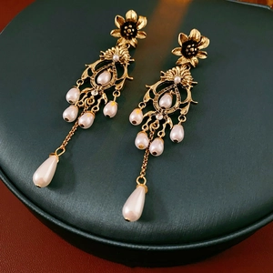 Macro view of vintage flower earrings with pearls and rhinestones on a jewelry box