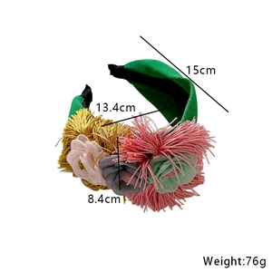 Green fabric floral headband with tassels and mesh flowers, 15cm size displayed