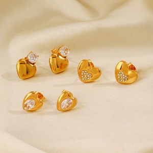 Tre paia di orecchini a lobo a cuore placcati oro 18K con zirconi lucidi su raso beige