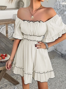 Detail of beige off-shoulder dress with puff sleeves and black contrast ruffled edges