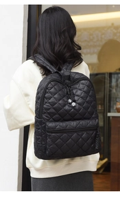 Dettaglio dello zaino in nylon nero trapuntato con texture morbida imbottita e chiusure lampo