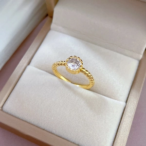 Minimalist gold bubble ring with sparkling round zircon in a velvet jewelry box