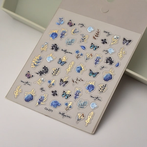 Détail de stickers ongles roses bleues avec accents dorés et motifs papillons