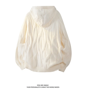 Detail view of cream cable-knit hoodie showing chunky twist texture and ribbed hem