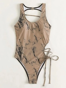 Detail of cutout waist with marble print and adjustable crisscross straps on swimsuit