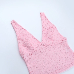 Detailansicht der rosa floralen Spitzentextur auf dem V-Ausschnitt Camisole-Top