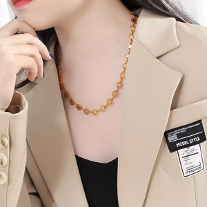 Detail of gold coin link chain necklace worn on model for a minimalist aesthetic