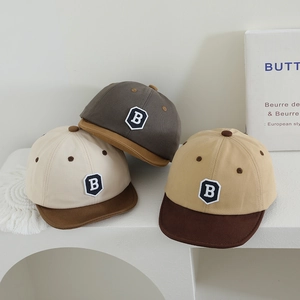 Detailed close-up of soft-brim baby baseball caps with embroidered letter B patch