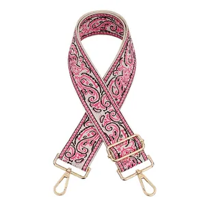 Close-up of jacquard paisley bag strap with golden metal swivel hooks and adjustable buckle