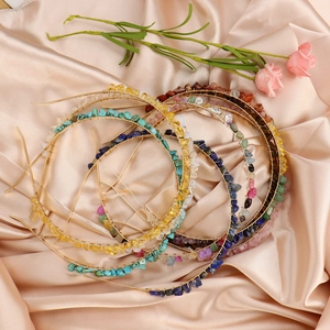 Handmade gold wire headbands with colorful natural crystal stones on silk background