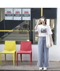 Detail of grey-blue wide-leg joggers with side white stripes and elastic drawstring waist