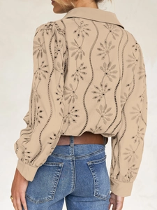 Detail of beige hollow-out embroidery floral pattern on the back of a casual woman's shirt