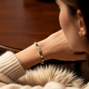Detail of 18k gold plated bracelet featuring emerald cut green zircon and crystal clusters