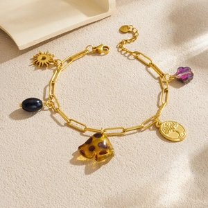 Gold plated charm bracelet with Tree of Life, sun, and leopard resin charms on sand
