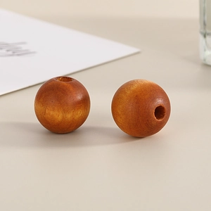 Close-up of two dark brown 16mm round wooden beads with natural grain and central holes