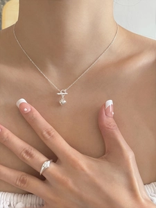 Detail view of 925 sterling silver heart pendant necklace and ring on a female model
