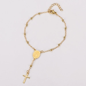 Détail du bracelet chapelet doré avec perles rondes et pendentif médaille religieuse