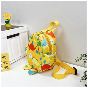 Detail of a bright yellow children backpack featuring colorful cartoon dinosaur prints