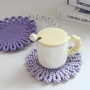 Detailed view of woven cotton flower-shaped coasters with a ceramic bubble handle cup
