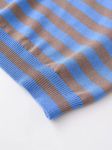 Close-up of striped knit fabric detail with blue and brown ribbing on the hemline