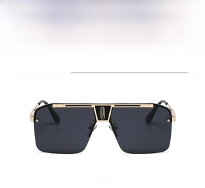 Vista frontal de gafas de sol de montura grande con puente de metal dorado y negro