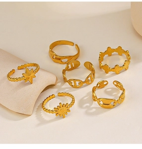 Set of six adjustable gold-plated rings with star and sun motifs on a soft background