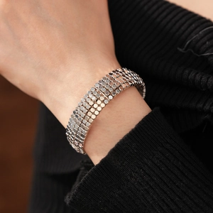 Gros plan d'un bracelet manchette argenté à paillettes multicouches sur un pull noir
