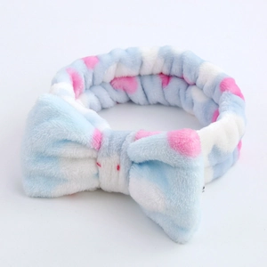 Detail of blue and white striped plush headband with pink polka dots and large bow