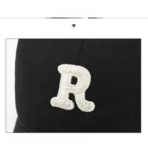 Close-up of premium white R letter embroidery on a black cotton twill baseball cap