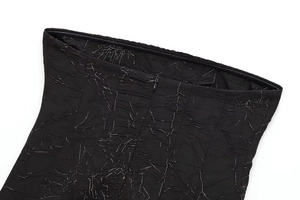 Detail of black pleated fabric with silver crackle finish and hidden zipper closure