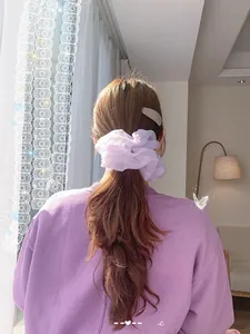 Detail of light purple organza scrunchie tied on a ponytail with soft pleated layers
