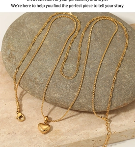 Détail d'un collier double couche avec pendentif cœur doré sur un galet gris lisse