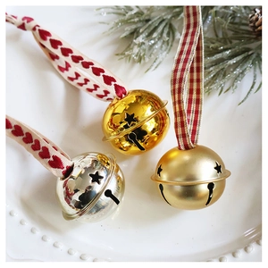 Detailed view of hollow star metal bells with festive ribbon ties and pine branch decor