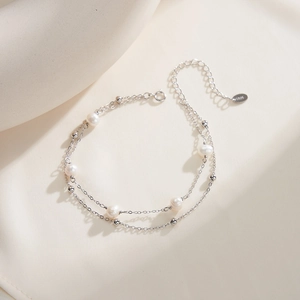 Macro detail of S925 sterling silver double-layer bracelet with natural pearls and beads